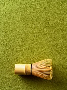 Powdered green tea Matcha background and bamboo whisk Chasen. Copy space for text or design. Vertical