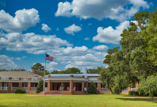 A public brick pavilion in a park with American flag out front