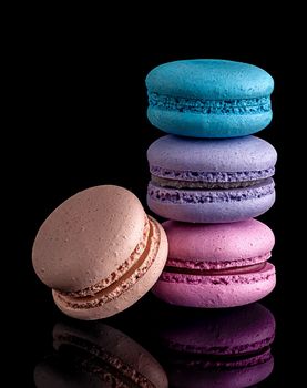Three macaroon each other and one next on black background