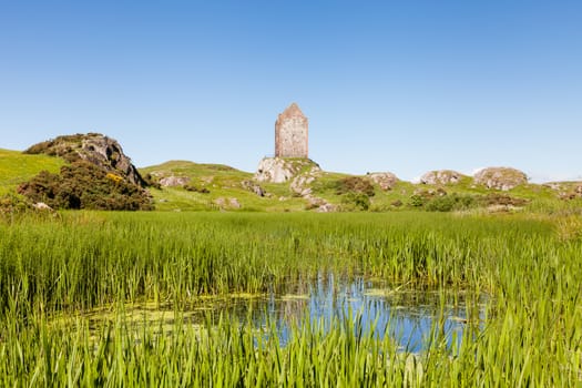 The view across a mill pond towards Smailholm Tower in the Scottish Borders.  The tower was built in the 1400's as protection from border raiders and the elements.