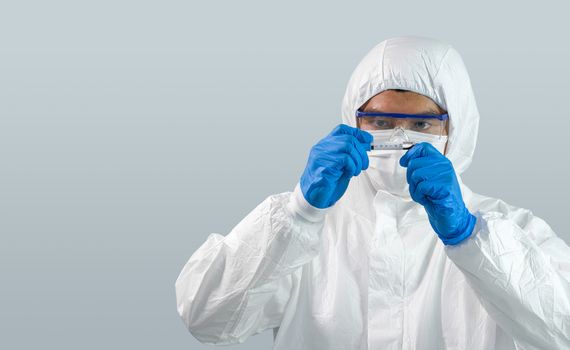Epidemiological researchers in virus protective clothing are looking at blood samples of patients infected with Covid-19. Coronavirus disease 2019 testing process in a laboratory.