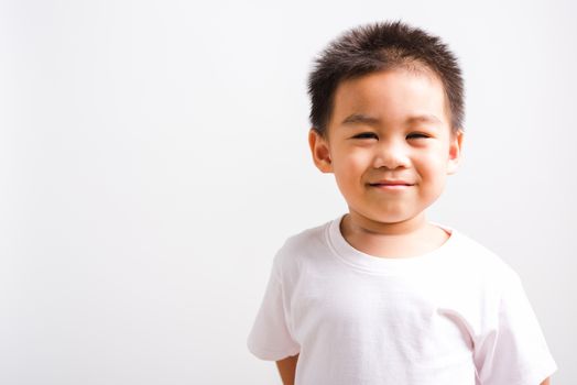 Closeup face Asian Thai portrait happy cute little child boy smiling wearing t-shirt he looking to camera, studio shot, isolated on white background with copy space