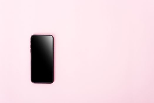 Top view of modern technology smart phone mobile on pink background with copy space