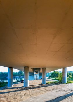 Concrete pillars under bridge on beach near river