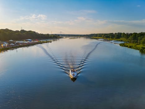 Beautiful landscape with boat making wave on river at sunny afternoon in Wroclaw city