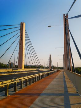 Red and gray pavement on huge Millennium bridge with large pillars in Wroclaw 