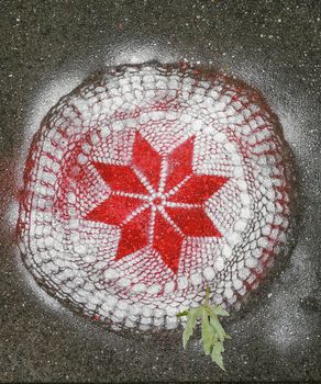 Lace pattern sprayed on pavement brick with red and white spray