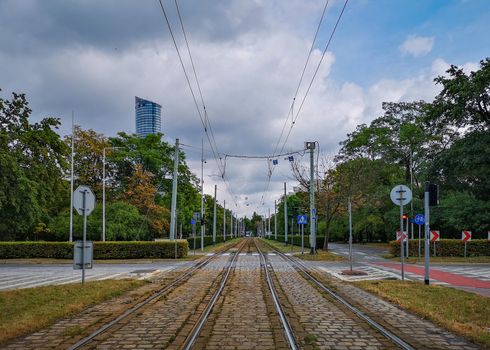 Street view from tram rails to roundabout in Wroclaw city with peak of skyscraper