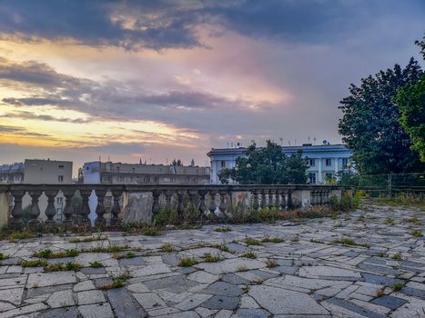 Purple sunset over old building ruins with concrete barrier