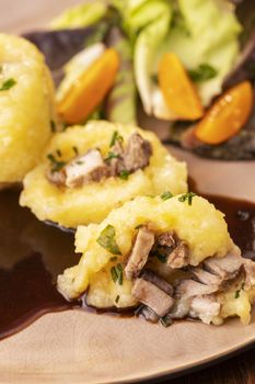 stuffed potato dumplings with salad on wood