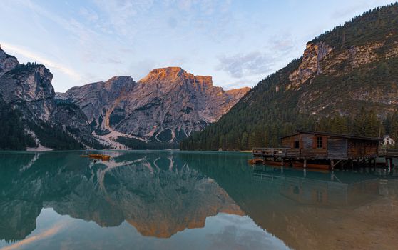 Mooring of boats on Lake Braies at first light in the morning, in the background the mountains of the Croda del Becco