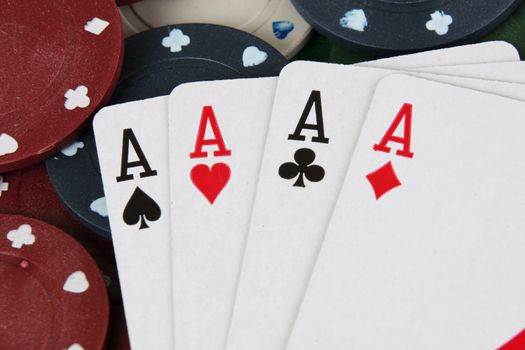 Four aces winning hand on a pile of betting casino chips