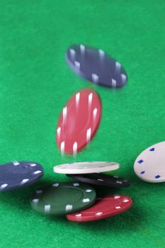 Splash the pot. Casino chips falling onto a card table with partial blur to illustrate movement
