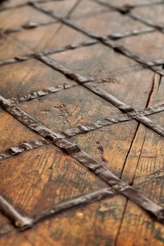 Fragment of an old brown wooden chest. Wood and forged metal on the chest cover.