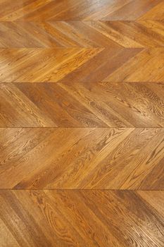 Fragment of brown wooden parquet floor. Wooden background.