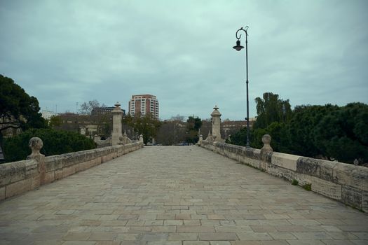 Old stone bridge in a big city, cloudy sky, classic, modern city