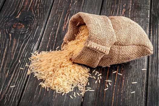 Sack of long rice lies on wooden background