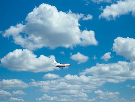 Private Falcon jet in blue skies over metal roof