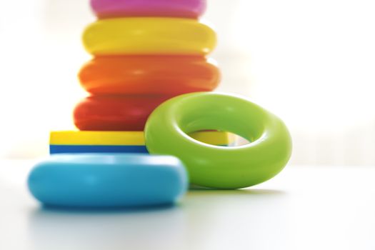 Colorful plastic rings on a white background to be stacked in a tower. Toy for newborns.