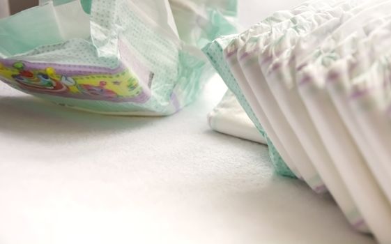 close-up view of a group of folded white diapers ready to be used. Health care of the newborn