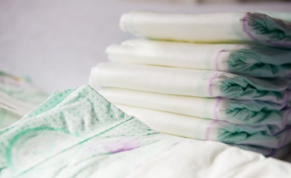 close-up view of a group of folded white diapers ready to be used. Health care of the newborn