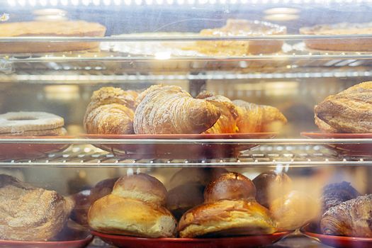 fresh croissants and other pastries for sale in a large bakery in Italy. Sweet food. Homemade food