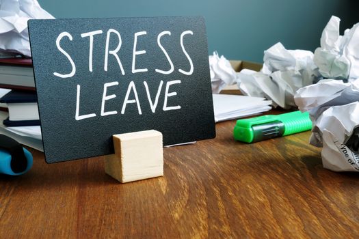 Stress leave concept. Office desk with paper balls.