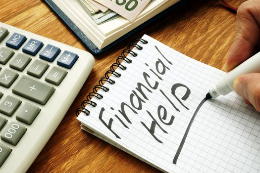 Man is writing financial help sign by marker.