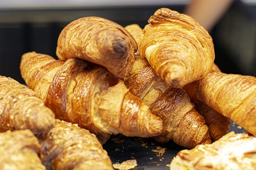 a group of croissants stacked on a tray. Baked product.