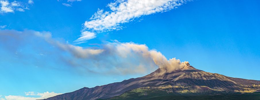 Overview of Mount Etna in Sicily during an eruption with smoke and ash release.