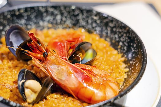 Valencian paella with rice, saffron and seafood served in a special pan. Typical recipe of Spanish cuisine.