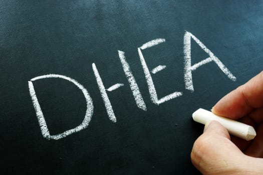 Dehydroepiandrosterone DHEA hormone and formula on the blackboard.