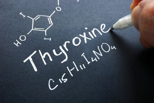 Thyroxine hormone sign on a black paper.