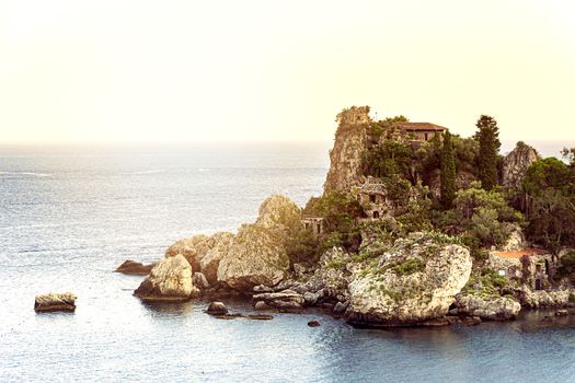 Isola bella islet in the bay of Taormina in Sicily at sunset. Sea and summer season. Tourist destination in Italy