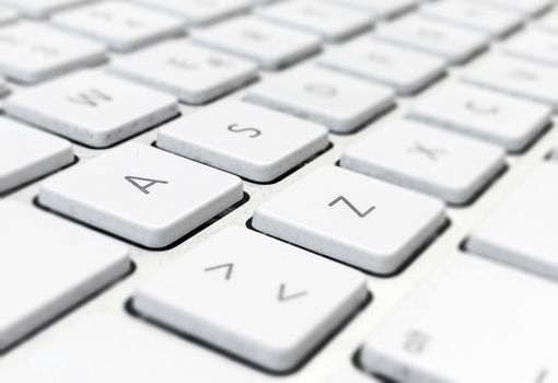 Close-up detail of a computer keyboard with white keys and a gray background. Letters and symbols on the keys. Technology and communication via the internet