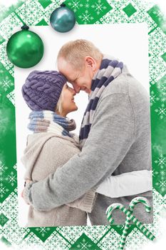 Happy mature couple in winter clothes hugging against christmas frame