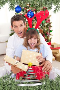 Surprised father and his girl opening Christmas gifts against twinkling stars