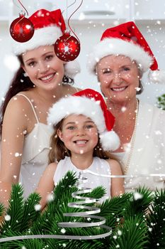 Daughter mother and grandmother baking Christmas sweets against snow falling