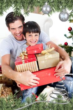 Happy father and son holding Christmas presents against twinkling stars