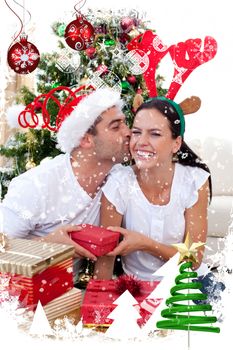 Smiling couple giving presents for Christmas against snow falling