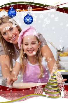 Mother and daughter baking Christmas cookies in the kitchen against snow falling