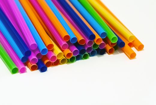 group of plastic straws of various colors on a white background. Global warming and plastic pollution. Environmental issues. Party and refreshment.