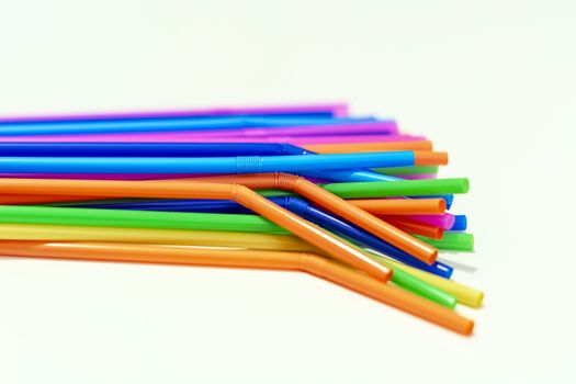 group of plastic straws of various colors on a white background. Global warming and plastic pollution. Environmental issues. Party and refreshment.