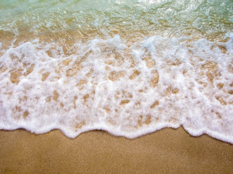 White bubble of Sea wave on fine sand at the beach