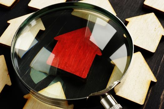 Property assessment for tax and sell. Wooden homes and magnifying glass.