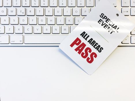 white card with permission to enter an event on a computer keyboard. Access valid for all areas of the event.