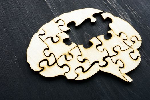 Alzheimers disease concept. Brain from wooden puzzles without one.