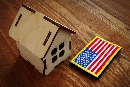 American flag and small house. VA mortgage loan concept.
