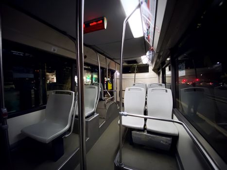 interior of a public transport bus with empty gray seats and no passengers. Transport and urban mobility. Wide angle shot