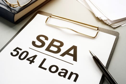 SBA 504 loan agreement form and clipboard.